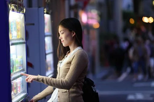 Customer selecting a product from a vending machine